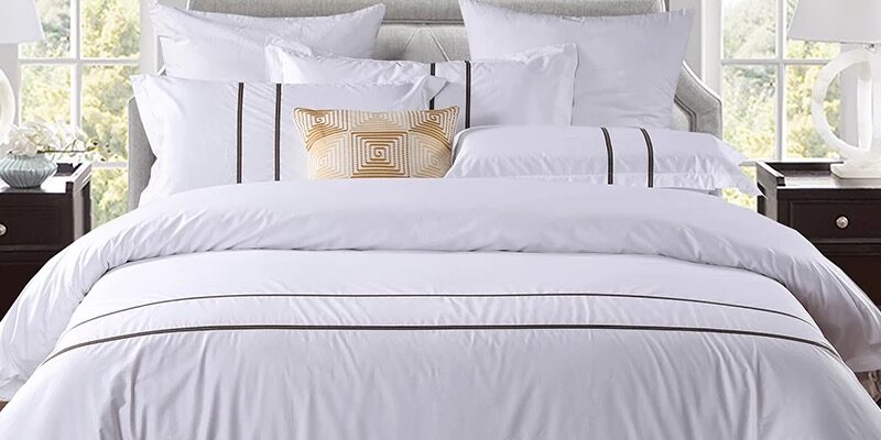 Luxury 100% Cotton Hotel Bedding Set – Soft & Clean White Design (1) Luxury 100% cotton hotel bedding set on a modern hotel bed in white
