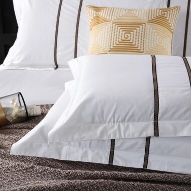 Luxury 100% cotton hotel bedding set on a modern hotel bed in white