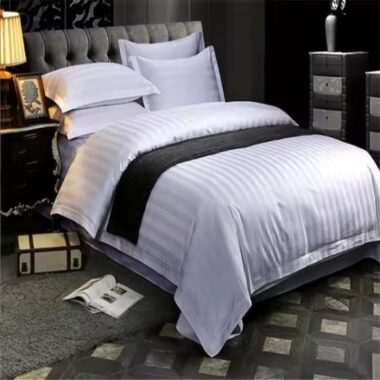 White premium down duvet bedding set arranged in luxury hotel guestroom